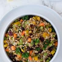 Colorful green orange and yellow vegetables with farro in a bowl