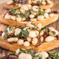 Crispy slices of bread topped with cannellini beans mixed with sun-dried tomatoes and crispy kale