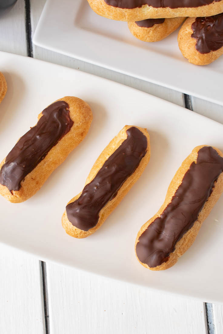 A plate of eclairs from above showing the chocolate topping