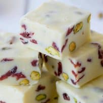 Gorgeous red cranberries against the white chocolate fudge and green pistachios