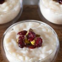 Creamy rice pudding with deep red dried cranberries and green pistachios