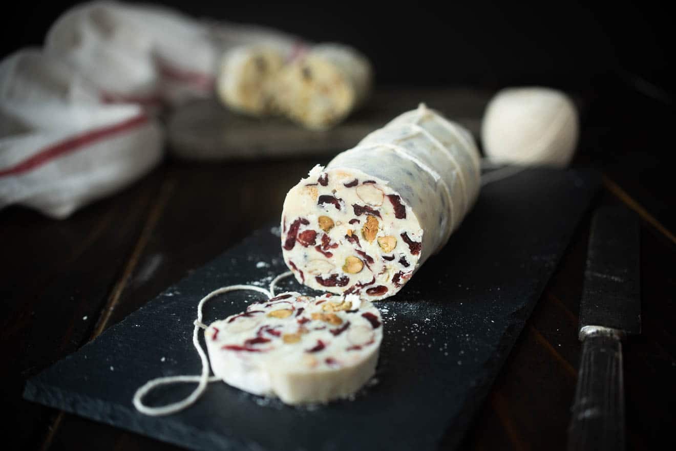 A white chocolate log studded inside with nuts, and dried cranberries