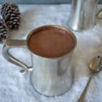 A pewter mug filled with Baileys Belgian hot chocolate on a bed of snow