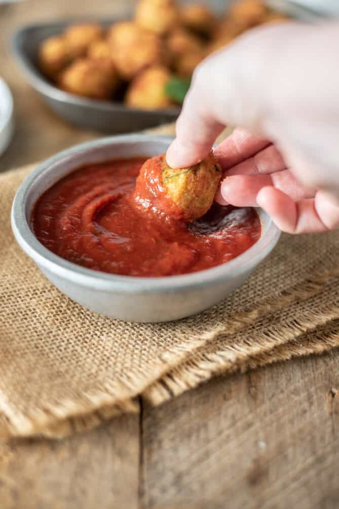 Dipping an Italian polpette croquette into tomato sauce