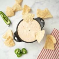 Queso viewed from above with tortilla chips and peppers